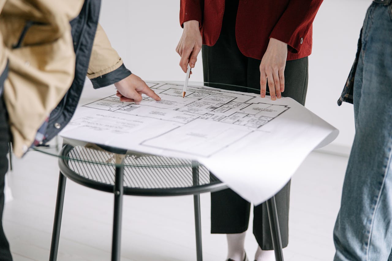 home-services-004 A group of people reviewing architectural blueprints on a table indoors.