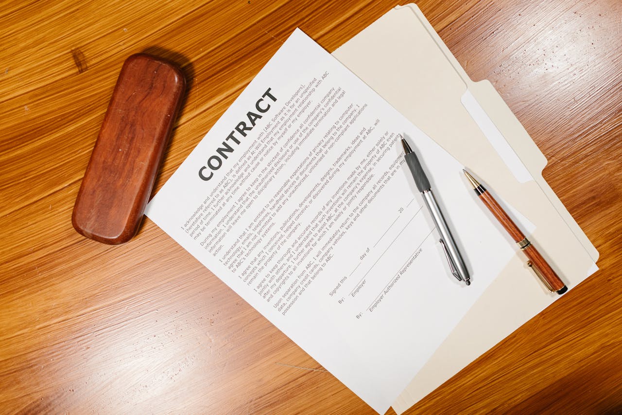 home-services-03 High-angle view of a contract document with pens and a case on a wooden table.